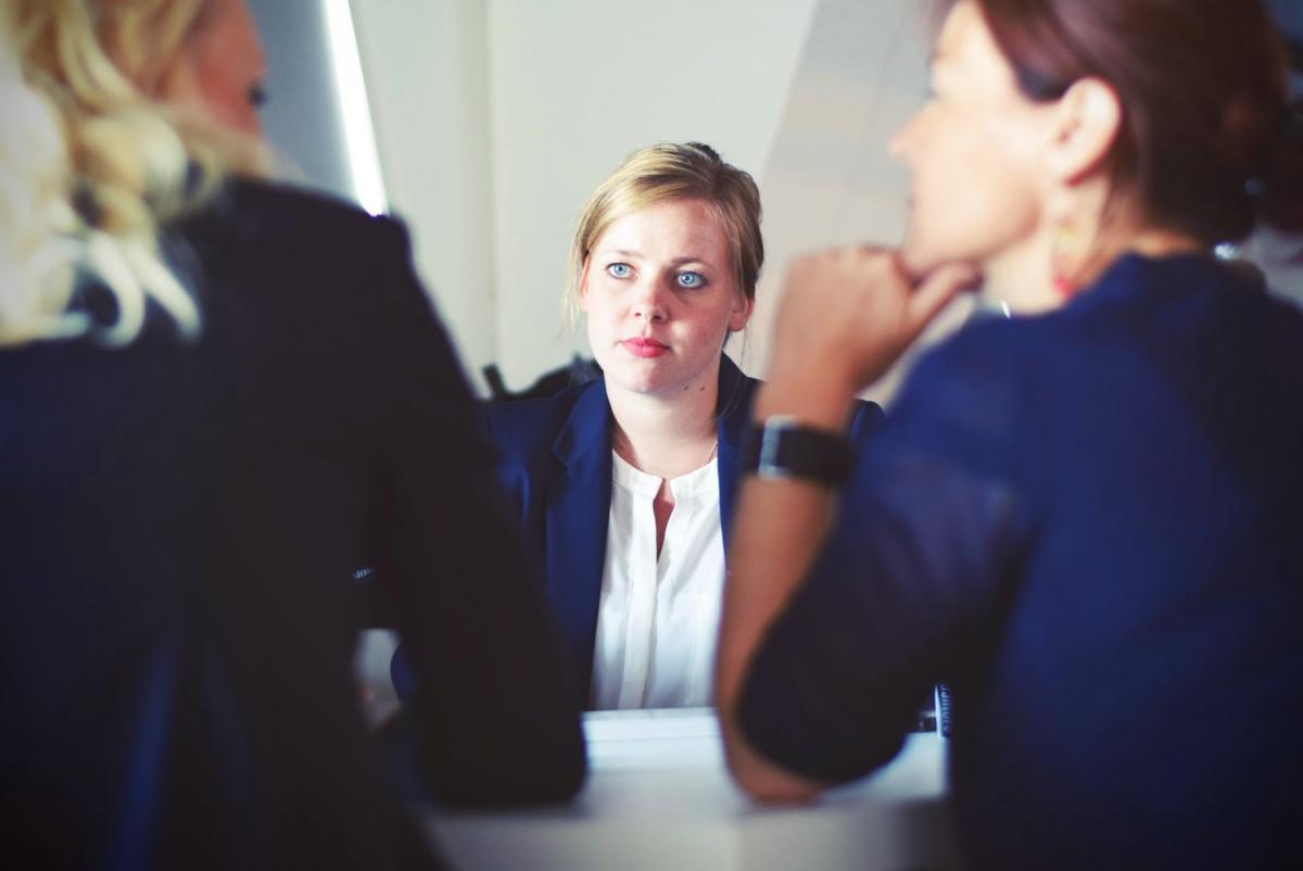 A team member listening to her teammates discuss a plan.